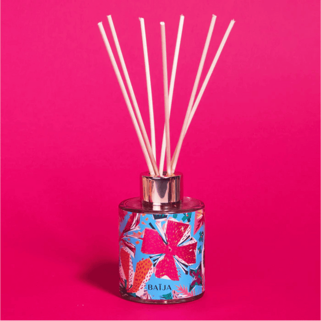 Reed diffuser with colorful design on a pink background