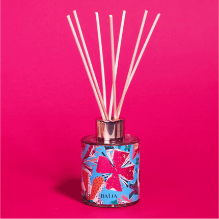 Reed diffuser with colorful design on a pink background